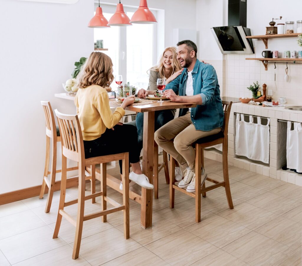 Happy family chatting and laughing while having dinner at home in Buckinghamshire